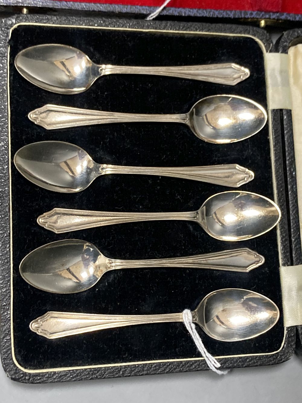 A cased set of six 1930s silver teaspoons and a cased set of six silver handled cake knives.